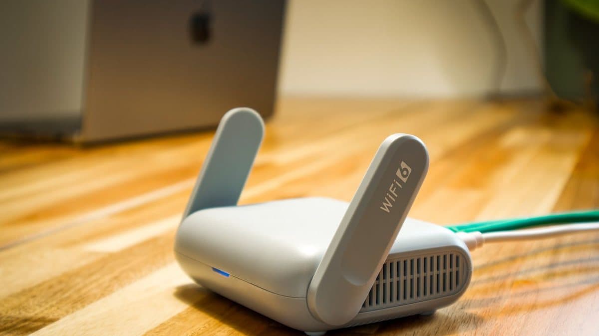 Modern Wi-Fi router on a desk representing the home network behind IPTV streaming