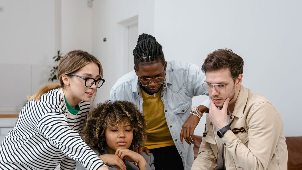 Group of people evaluating options together around a laptop