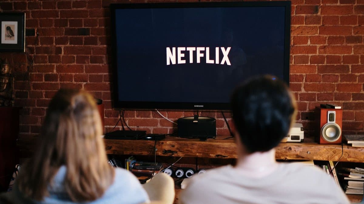 Couple watching live television together in their living room