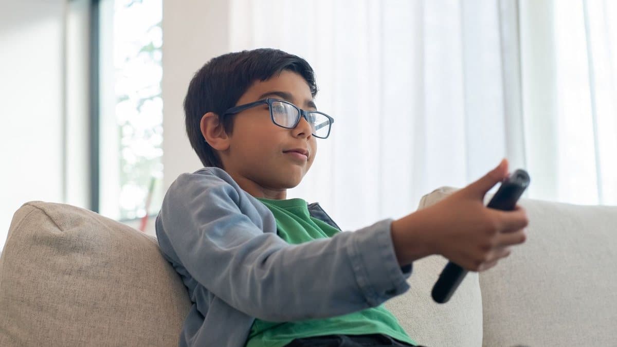 Person holding a television remote control in a living room