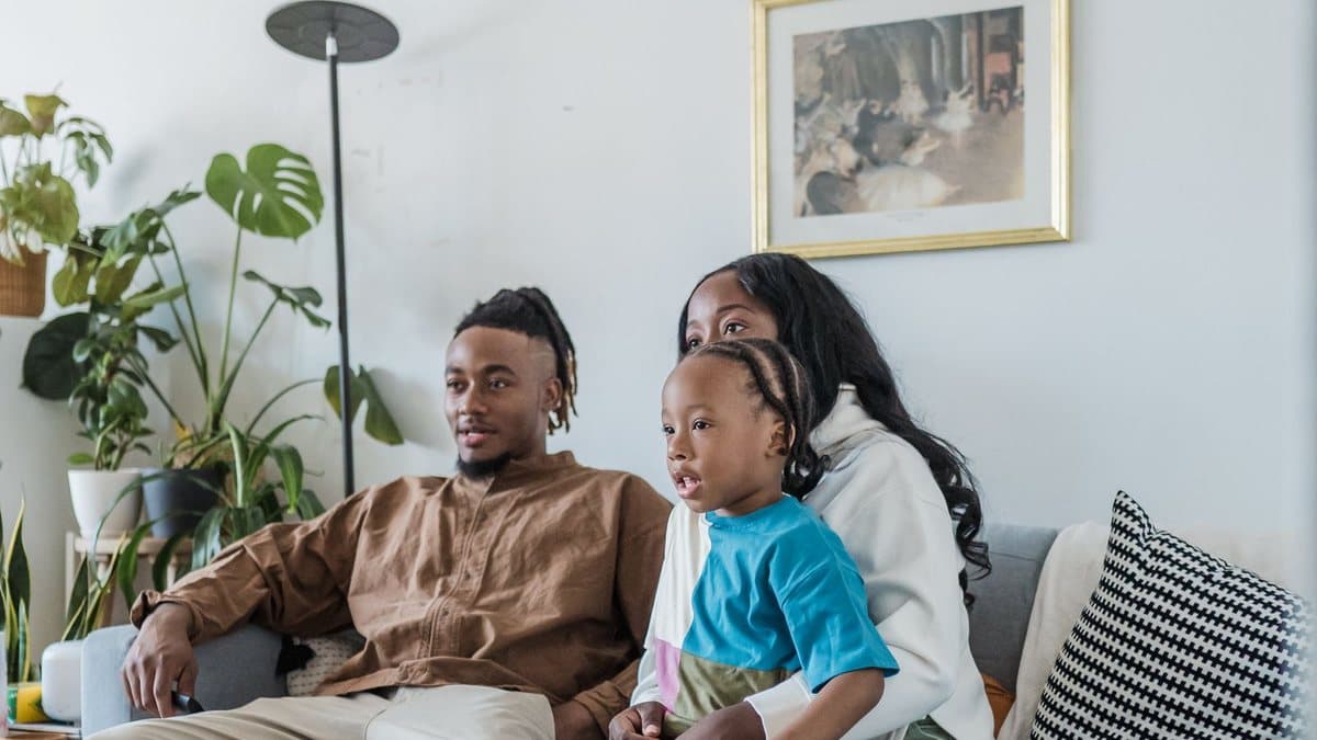 Family watching television together on a couch