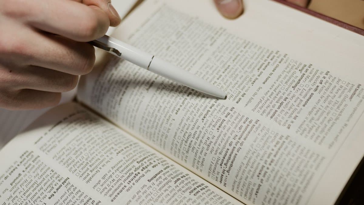 Close-up of a person carefully reviewing printed terms with a pen