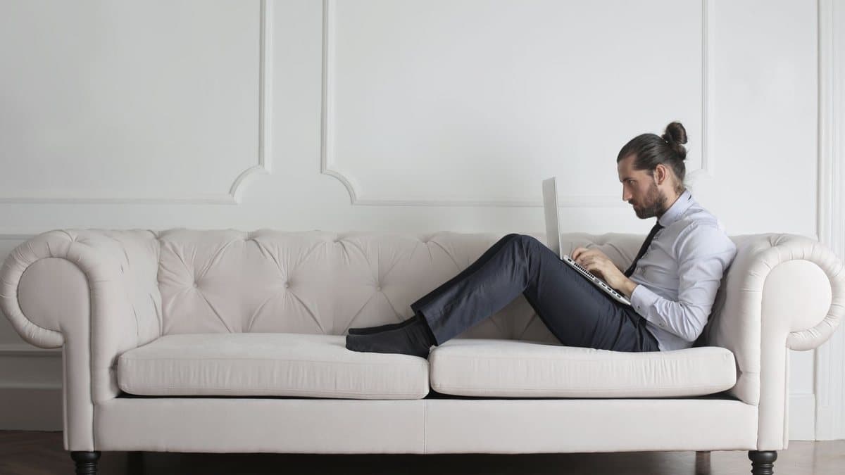 Person sitting on a couch, representing choosing between streaming options