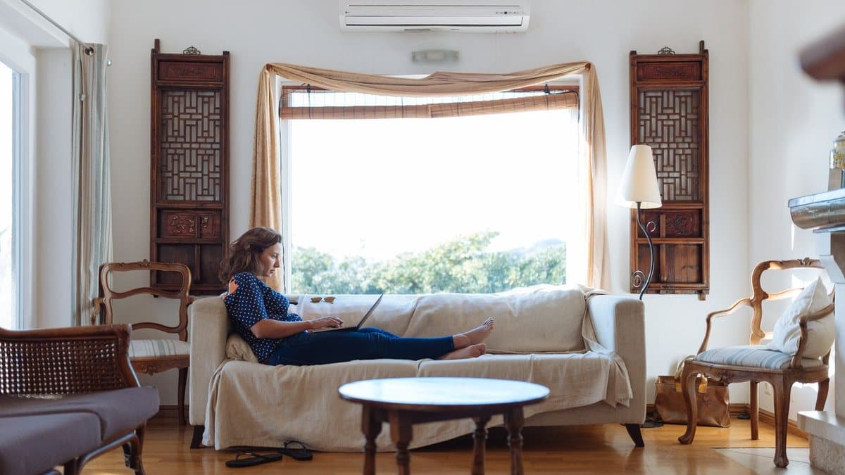 Person relaxing on a sofa at home, considering whether a streaming service fits their needs