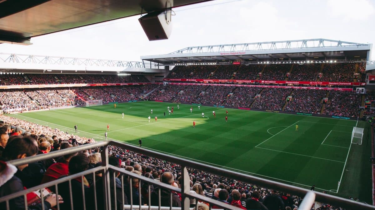Group of people watching a live football match together on television